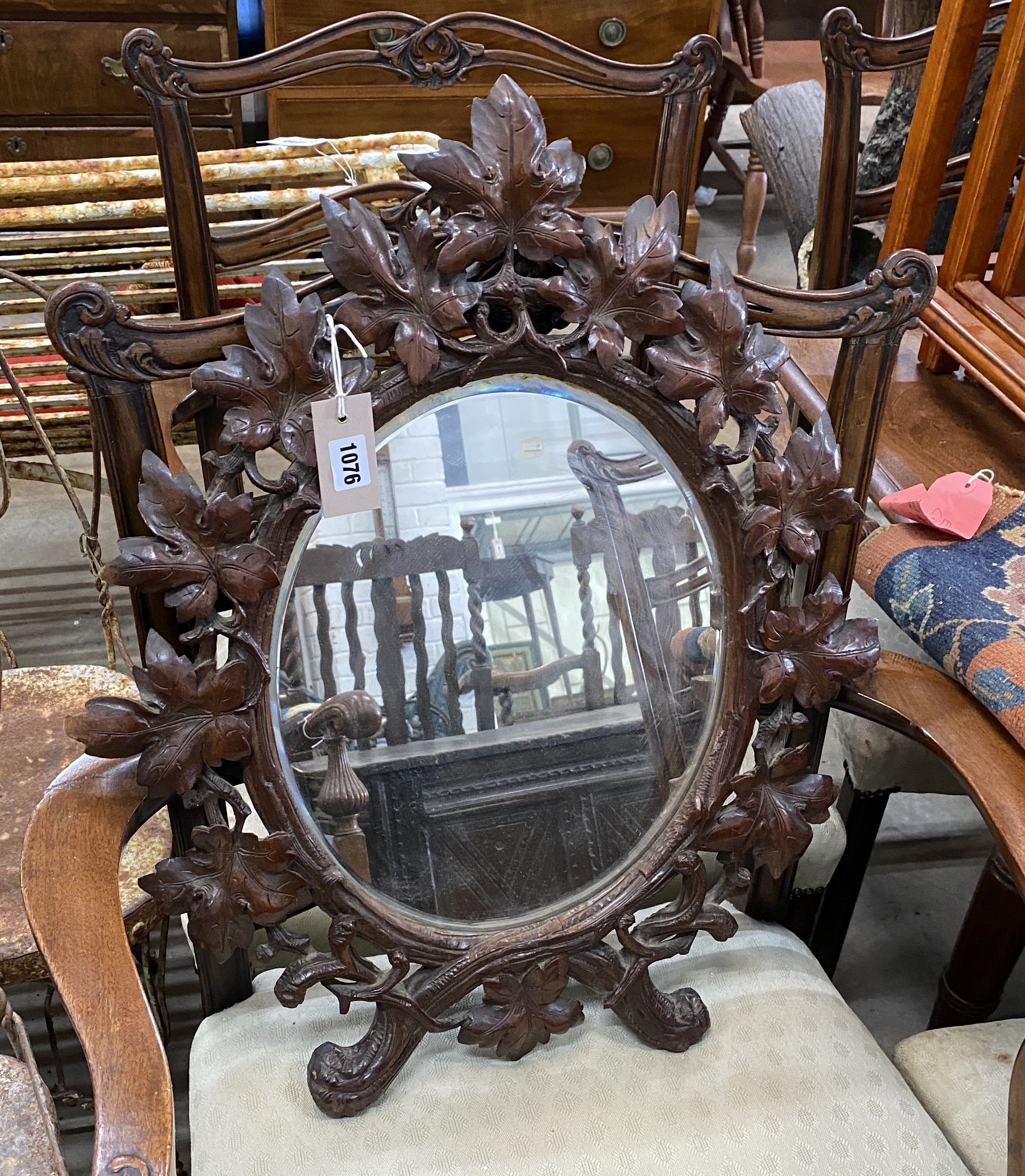 A 19th century oval Black Forest carved walnut wall mirror, width 54cm, height 66cm